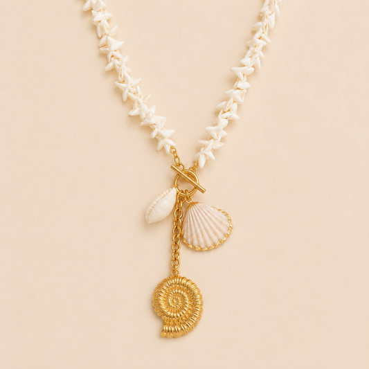 Estate NECKLACE with a beaded white shell chain and gold toggle clasp holding cowrie, scallop and nautilus shell charms.