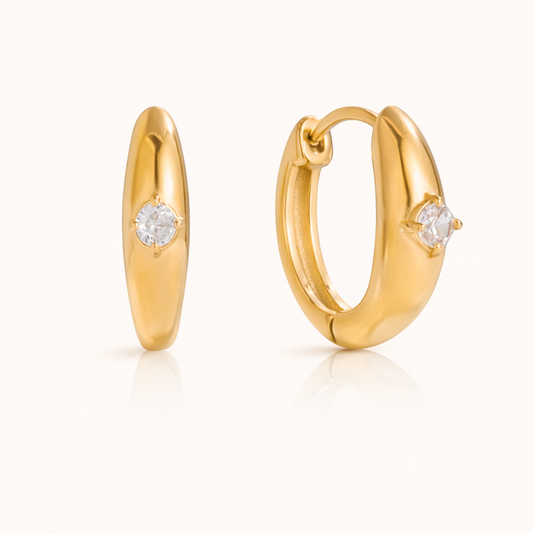 The Everyday Drama EARRINGS are chunky gold huggie hoops, each set with a single sparkling round crystal.