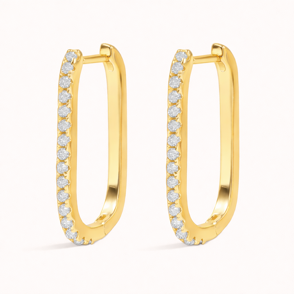 Fair Game Earrings form an elongated oblong hoop lined with pave crystals along one edge, shown here in polished gold.