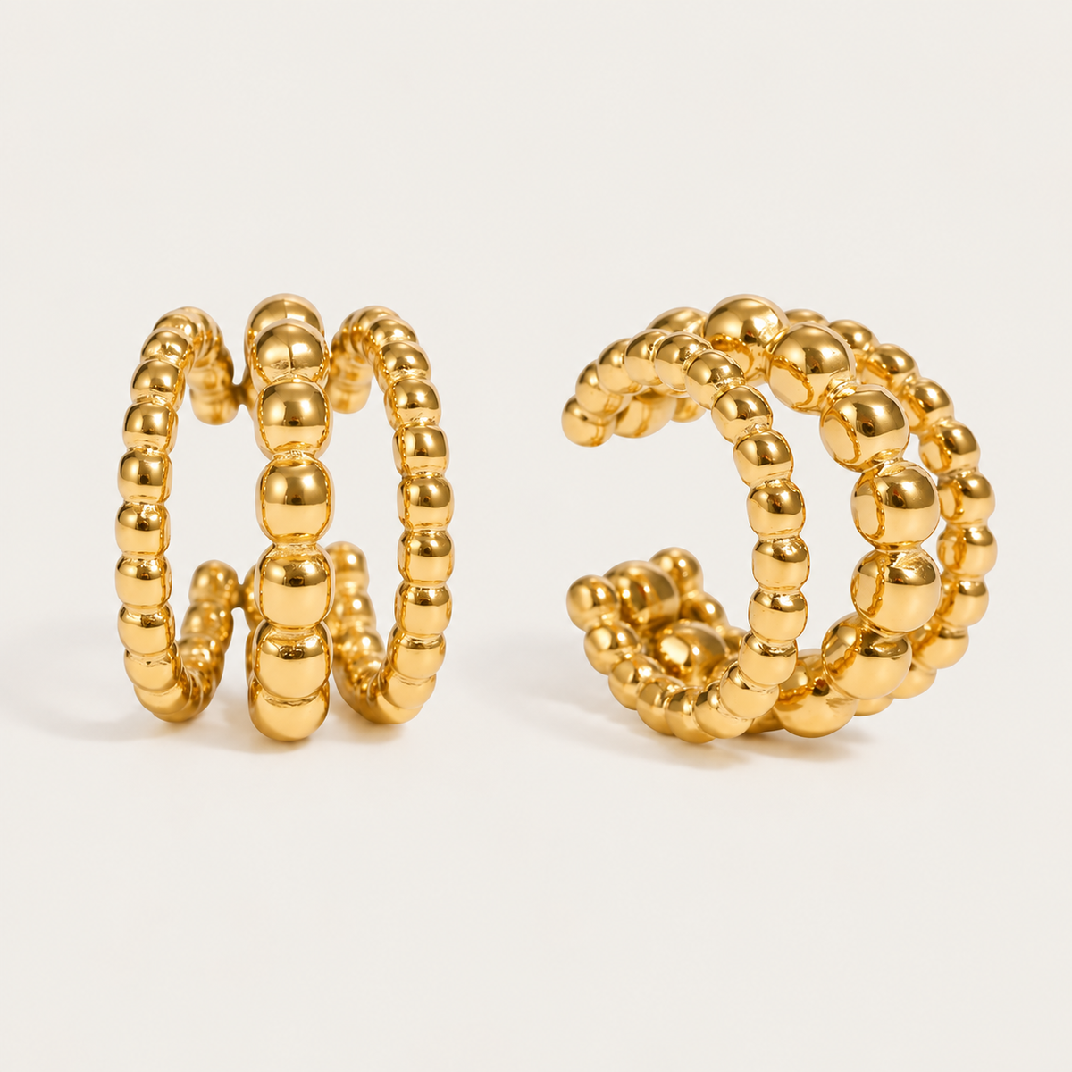 Pair of gold beaded ear cuffs with a double row of graduated balls, product shot for the Folie à Trois Felix EAR CUFF.