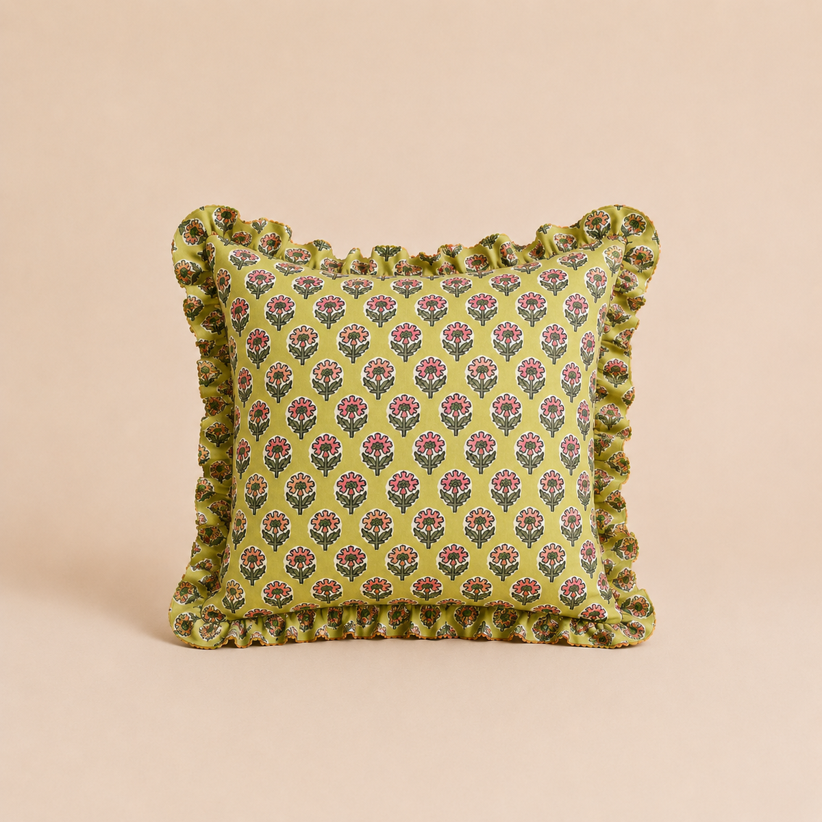 Fern Dream Square cushion in chartreuse green with a pink block-print floral pattern and a matching ruffled border on a beige backdrop.
