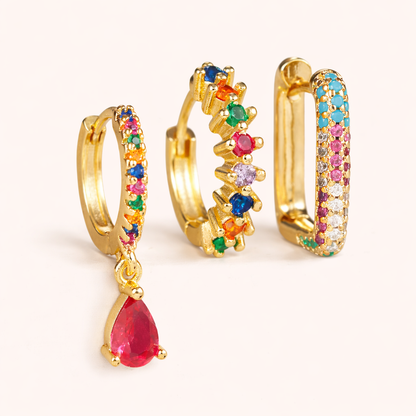 The Fia SET is shown in a multicolor rainbow gemstone colorway across its drop huggie, zigzag hoop, and pave hoop.