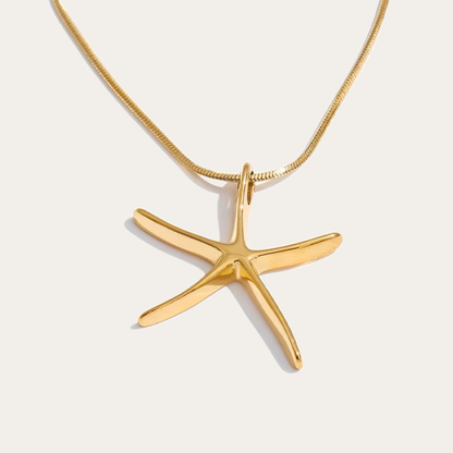The Fiji NECKLACE in gold, its sculptural starfish pendant shown alone on a fine snake chain against a plain studio background.