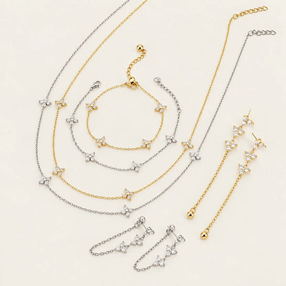 Fiore collection flat lay: gold and silver-tone flower necklaces, bracelets and chain earrings — Folie à Trois jewelry