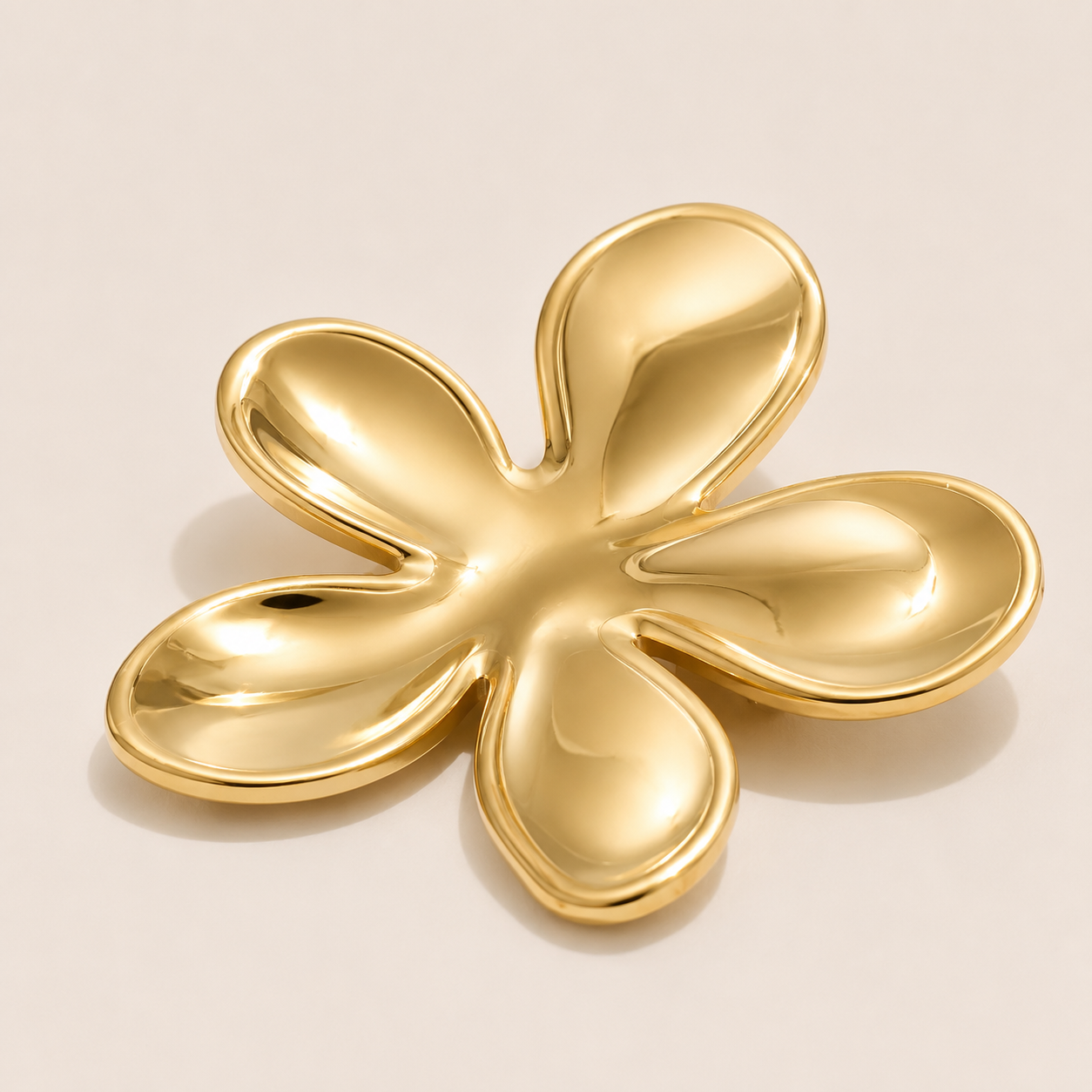 Gold five-petal flower brooch with a glossy sculptural finish on a cream backdrop — Folie à Trois Flora BROOCH