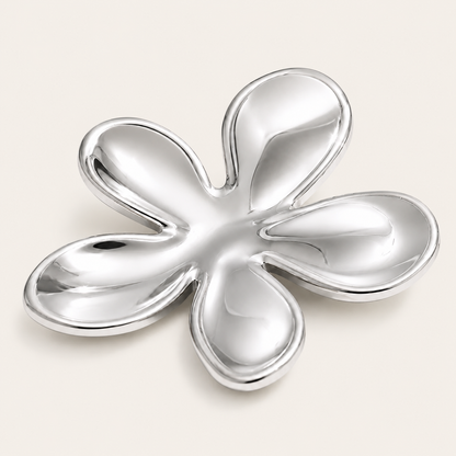 Silver five-petal flower brooch with a glossy sculptural finish on a cream backdrop — Folie à Trois Flora BROOCH