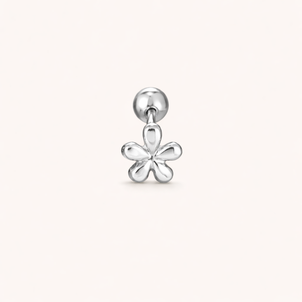 The Flower PIERCING is shown in silver, a labret stud topped with a small five-petal flower charm design.