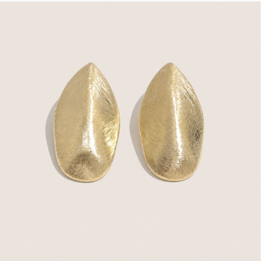 Gold leaf-shaped stud earrings with a brushed textured finish on a cream backdrop — Folie à Trois Foglia EARRINGS