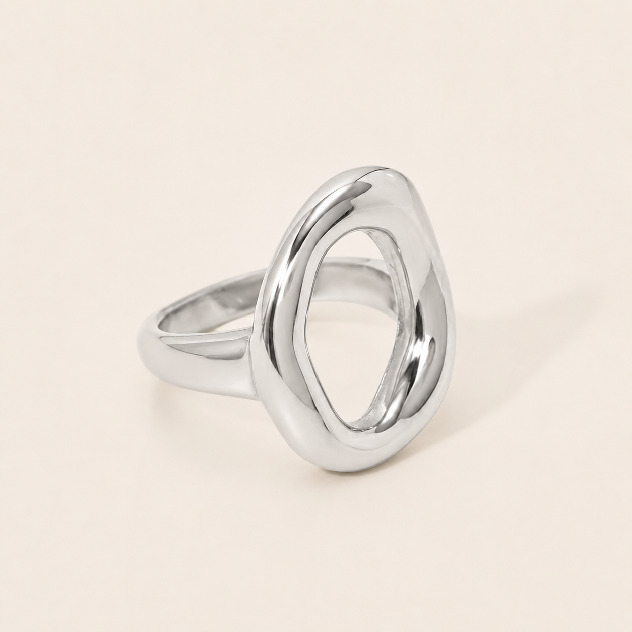 Silver Formentera RING with an open, asymmetric organic loop and a chunky polished band, shown in close-up on a cream backdrop.