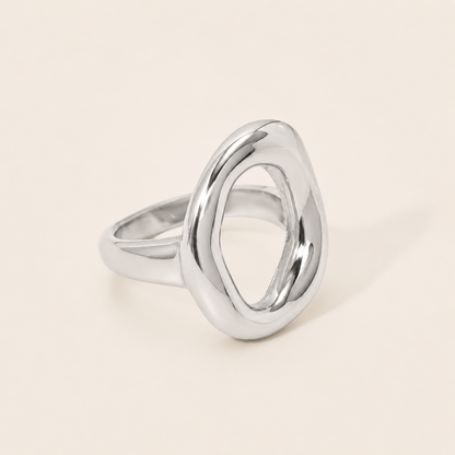 Silver Formentera RING with an open, asymmetric organic loop and a chunky polished band, shown in close-up on a cream backdrop.