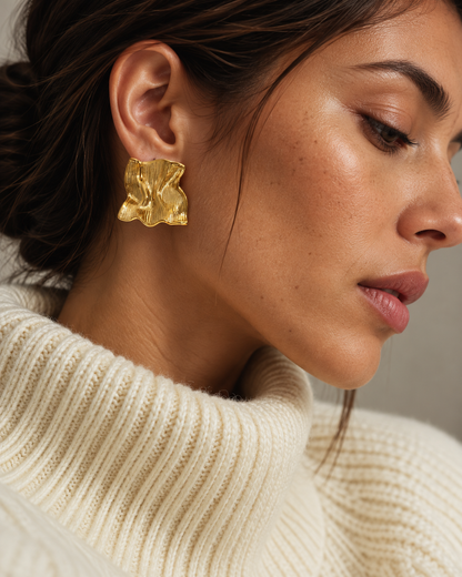 Gold Froissé EARRINGS, chunky square studs with a crinkled texture, worn with a cream turtleneck — Folie à Trois