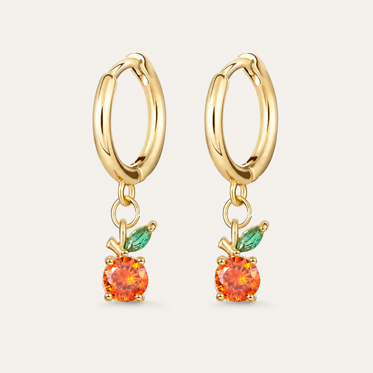 Gold huggie hoop earrings from the Fruit Hoop EARRINGS with a round orange cubic zirconia charm and a green marquise leaf accent.