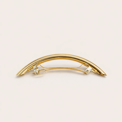Gia HAIR CLIP curved gold-tone metal barrette with ridged texture, studio shot.
