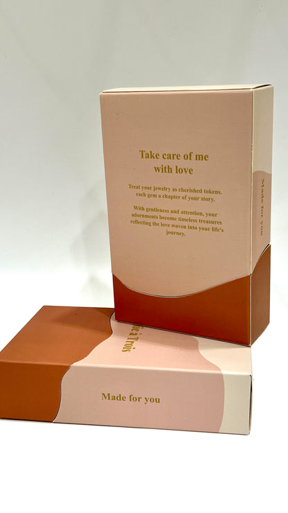 Open Folie à Trois gift box showing its take care of me with love message stacked on a closed matching box.