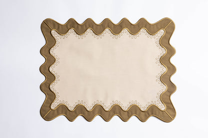 Olive-green scalloped placemat with a cream center and gold-stitched trim, the Gisèle Scallop placemat with embroidered detail.