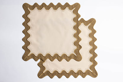 Close-up of a folded olive-green napkin with a cream piped scalloped edge, from the Gisèle Scallop napkins with embroidered detail.