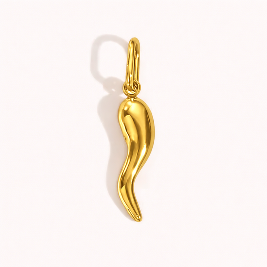The Gold Chili Pepper CHARM in a studio flat lay, a curved polished gold pendant in a chili pepper silhouette on a cream background.