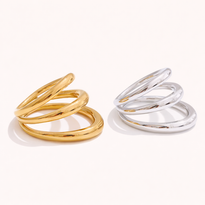 Gold and silver Harley RING styles, each with three interlocking smooth bands, shown together on a cream backdrop.