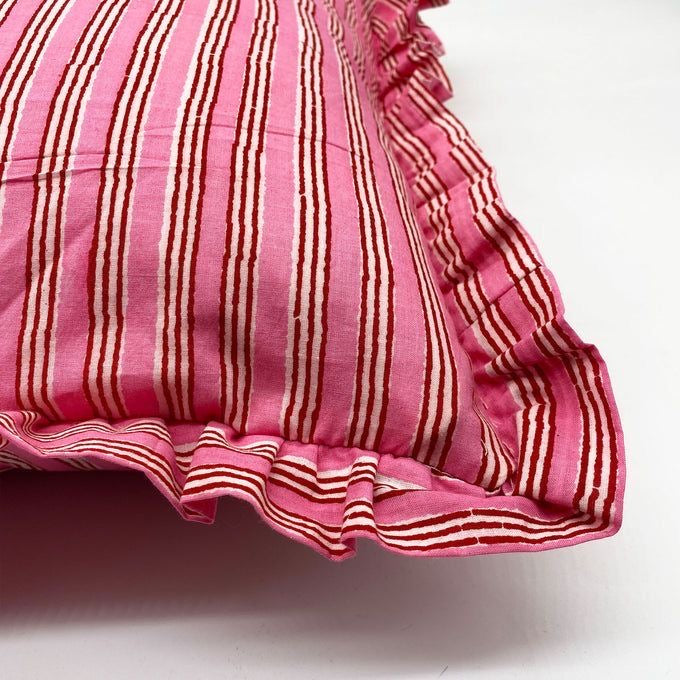 Flat lay of the Harmony Pink Rectangle cushion in bold red linen with a white scalloped edge and a small bow detail.