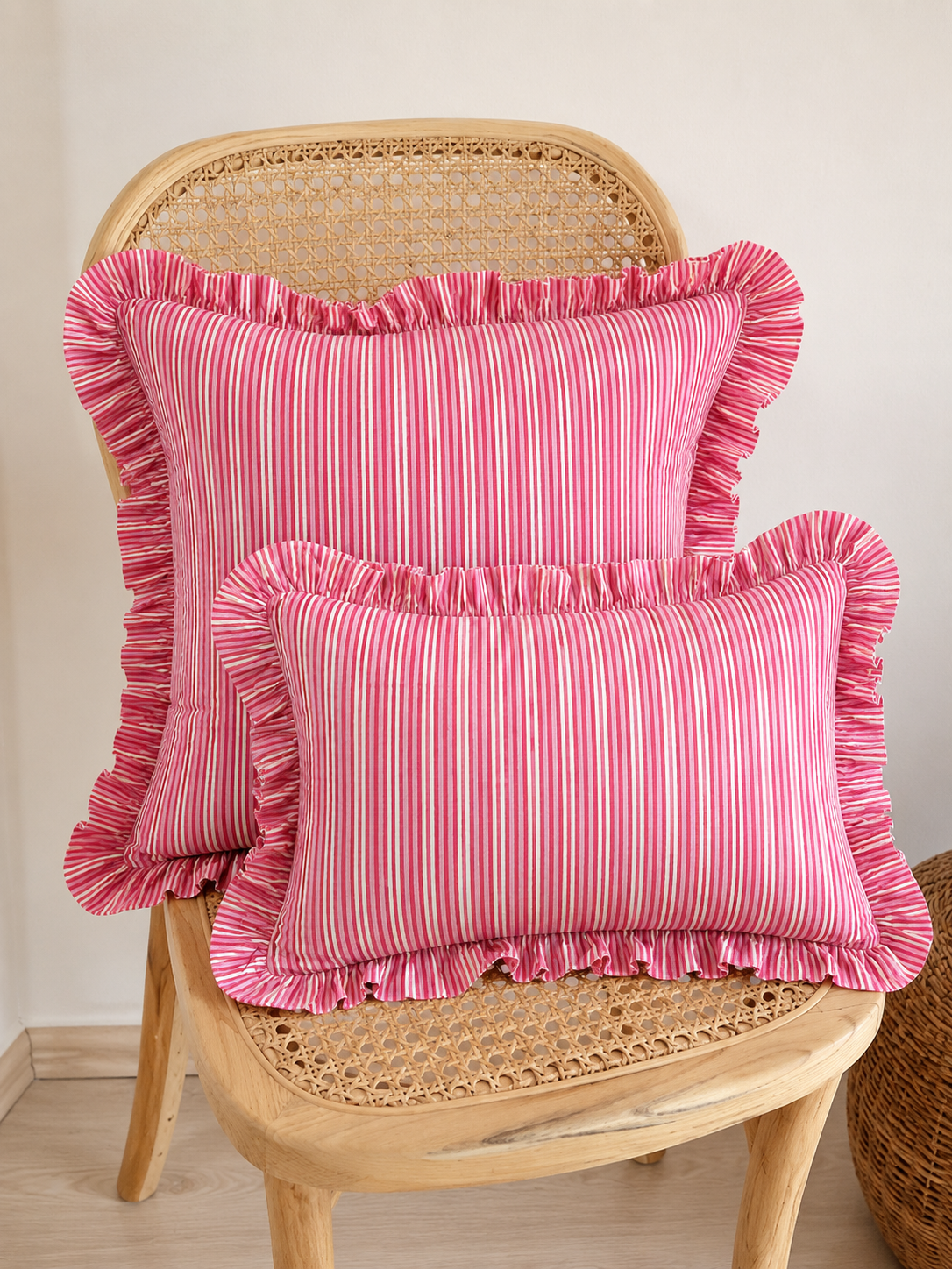 Close-up of the Harmony cushion's folded orange linen corner with white scalloped embroidered edge detail.