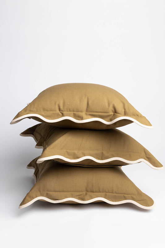 Olive-green Harper Linen cushion fabric doubles as a table linen under white plates and coffee cups in a brunch tablescape with artichokes.