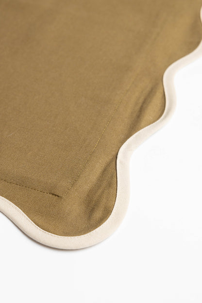 Macro detail of the Harper Linen cushion's scalloped edge, showing olive-green fabric bordered with gold embroidered stitching.