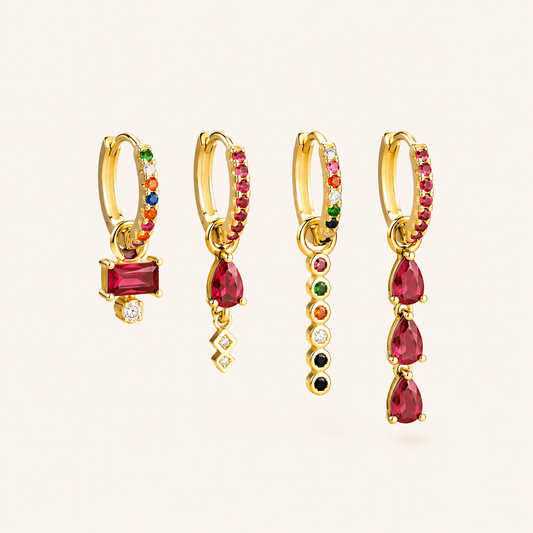 Harper Set of four gold huggie hoops with dangling charms in ruby, garnet, and multicolor gemstone accents.