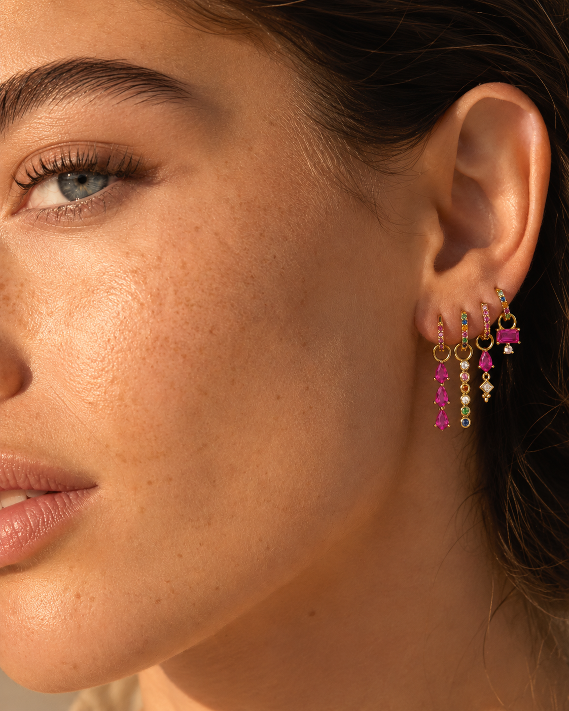 Close-up of the Harper Set worn as an ear stack, colorful gemstone drop charms catching the light nicely.