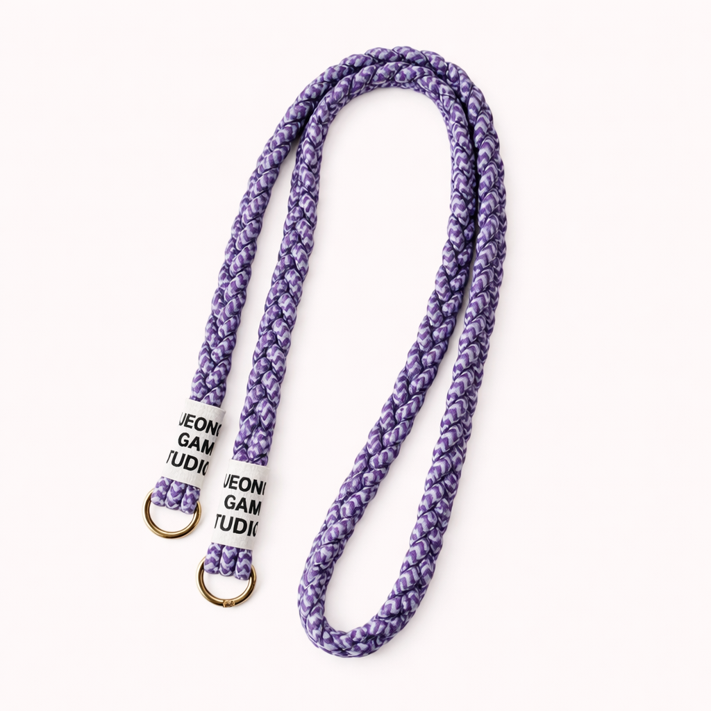 Purple braided cord Havana long phone strap with fleck detailing, coiled with gold ring hardware.