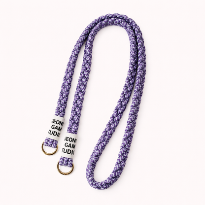 Purple braided cord Havana long phone strap with fleck detailing, coiled with gold ring hardware.