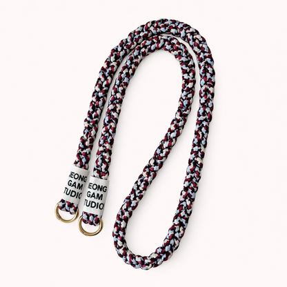 Maroon, navy, and gray braided cord Havana long phone strap, coiled with gold ring hardware.