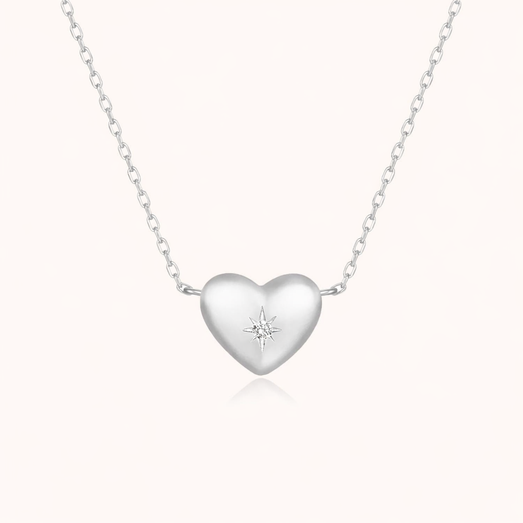 The Heart Me NECKLACE in silver, a puffed heart pendant set with a tiny star-shaped stone, on a fine chain.