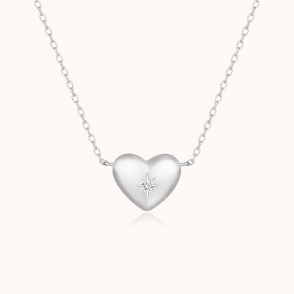 The Heart Me NECKLACE in silver, a puffed heart pendant set with a tiny star-shaped stone, on a fine chain.