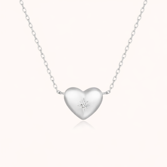 The Heart Me NECKLACE in silver, a puffed heart pendant set with a tiny star-shaped stone, on a fine chain.