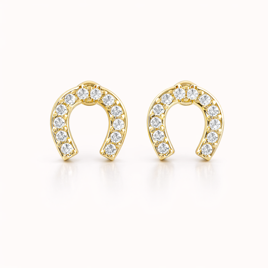 The Horseshoe EARRINGS are gold studs shaped like horseshoes, fully lined with sparkling round crystals.