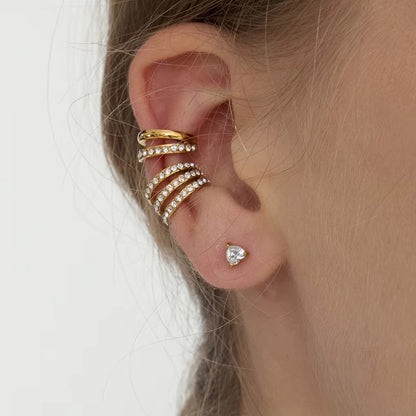 Hotline Ear Cuff worn on the ear cartilage, the pave crystal band stacked above a small heart-shaped stud earring.