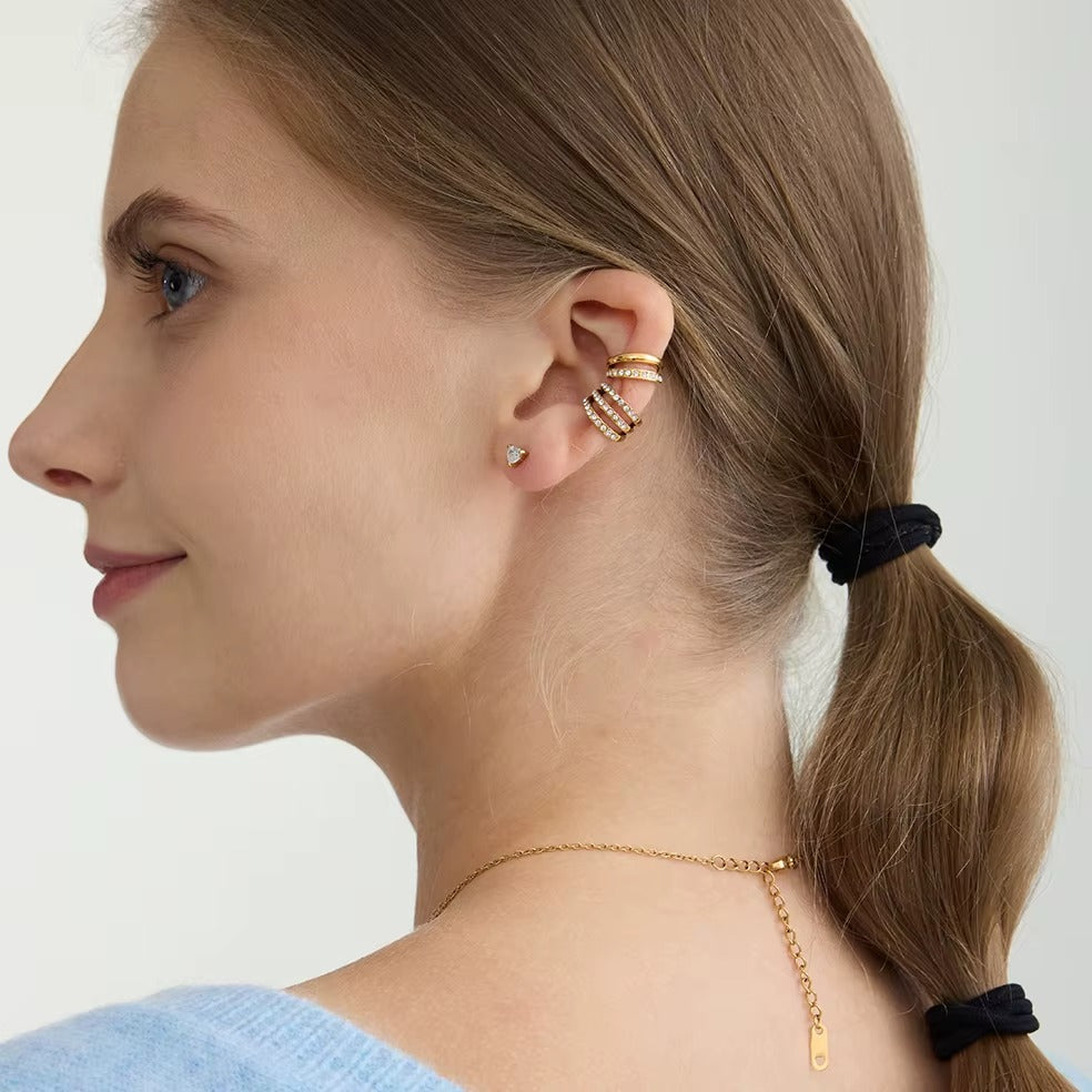 Hotline Ear Cuff worn in profile on a model in a ponytail, paired with a gold chain necklace and a heart stud.