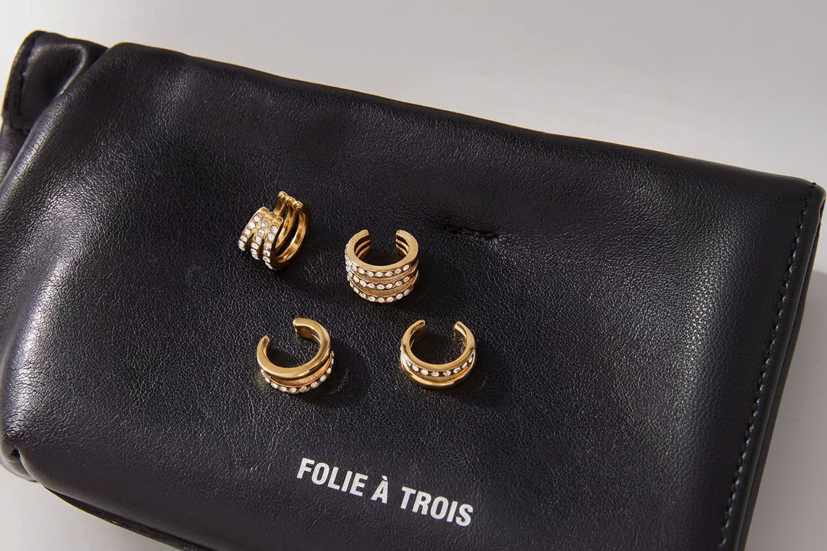 Hotline Ear Cuffs shown with the Wildcard cuffs on a black Folie a Trois pouch, highlighting the double-band and pave crystal designs.