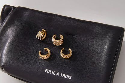 Hotline Ear Cuffs shown with the Wildcard cuffs on a black Folie a Trois pouch, highlighting the double-band and pave crystal designs.