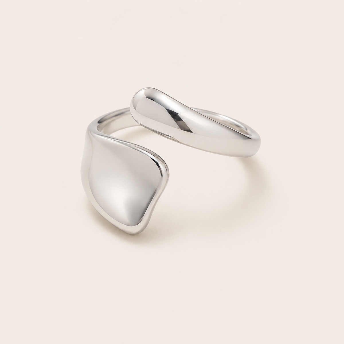 Silver open ring with an asymmetric organic panel overlapping a slim curved band, shown on a cream backdrop — Folie à Trois Hydra RING.