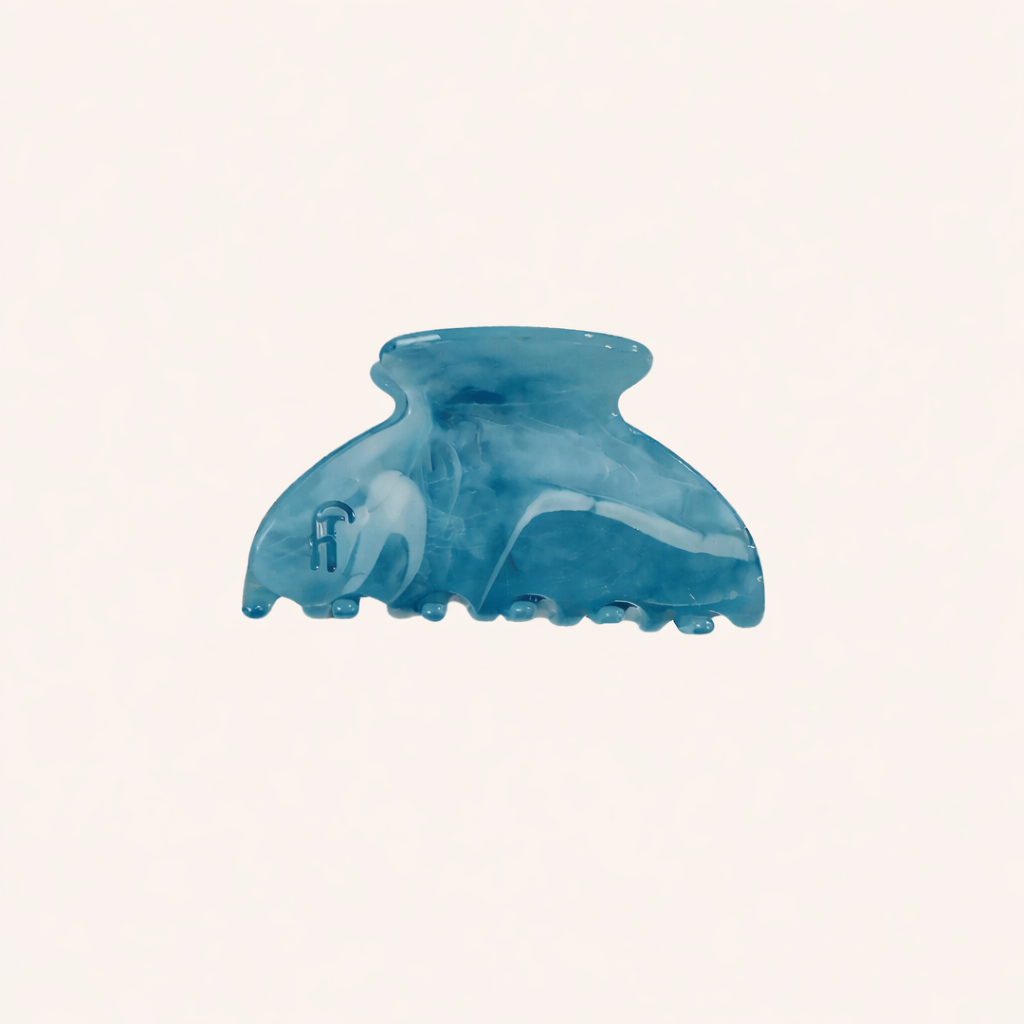 Blue marbled acetate claw clip from the Ice Queen HAIR CLIP collection, shown on a cream studio background.