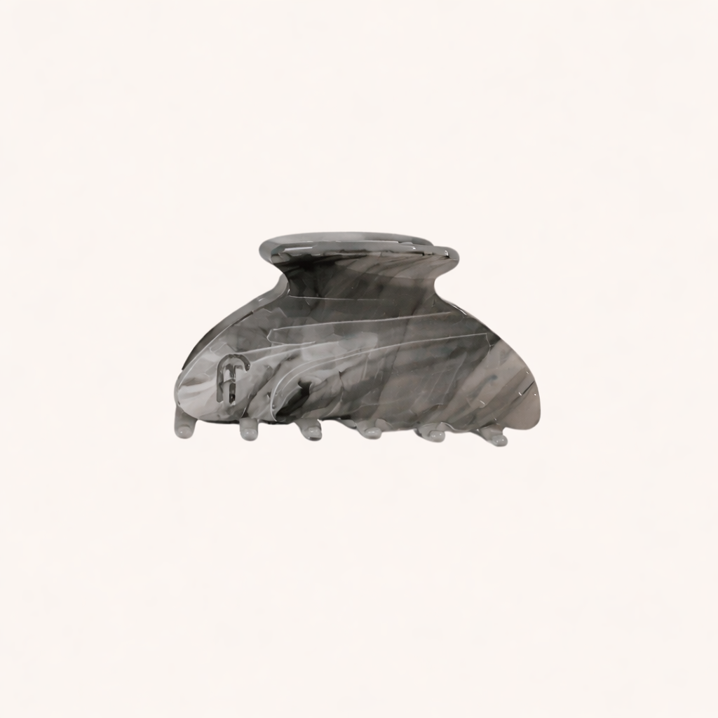 Grey and charcoal marbled acetate claw clip from the Ice Queen HAIR CLIP collection, shown on a cream studio background.