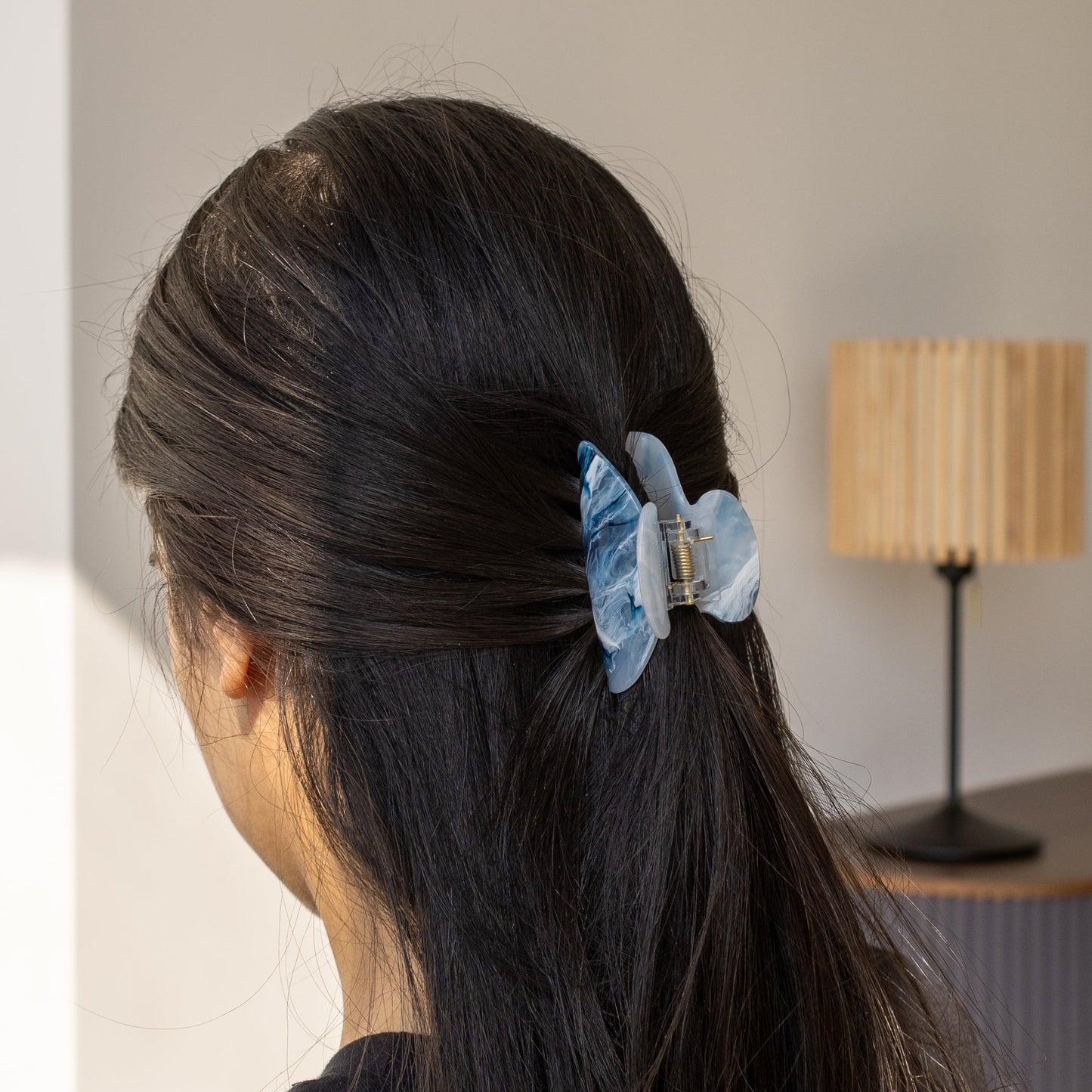 Ice Queen HAIR CLIP's blue marbled claw clip worn in a half ponytail, clipped into dark hair indoors.