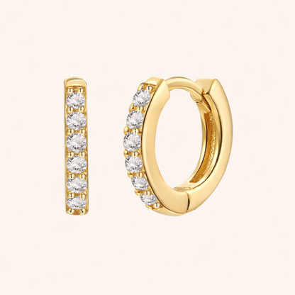 In a Dream Earrings in gold with clear crystals, showing the six-stone pave huggie hoop design.