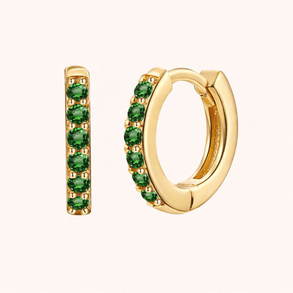 In a Dream Earrings in gold with emerald-green crystals, the huggie hoop set with six round graduated stones.