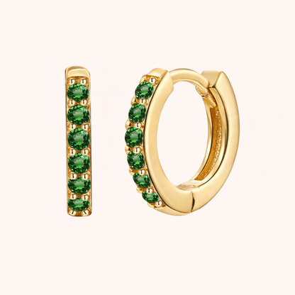 In a Dream Earrings in gold with emerald-green crystals, the huggie hoop set with six round graduated stones.
