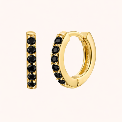 In a Dream Earrings in gold with black crystals, showing the six-stone pave huggie hoop design.