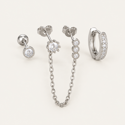 The Folie à Trois Ines SET in silver: a bezel stud, a bezel stud linked by chain to three small drops, and a pavé huggie hoop.