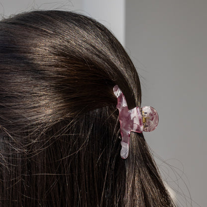 Iris HAIR CLIP in a purple and white striped pattern, worn half-up on dark hair, close-up back view.