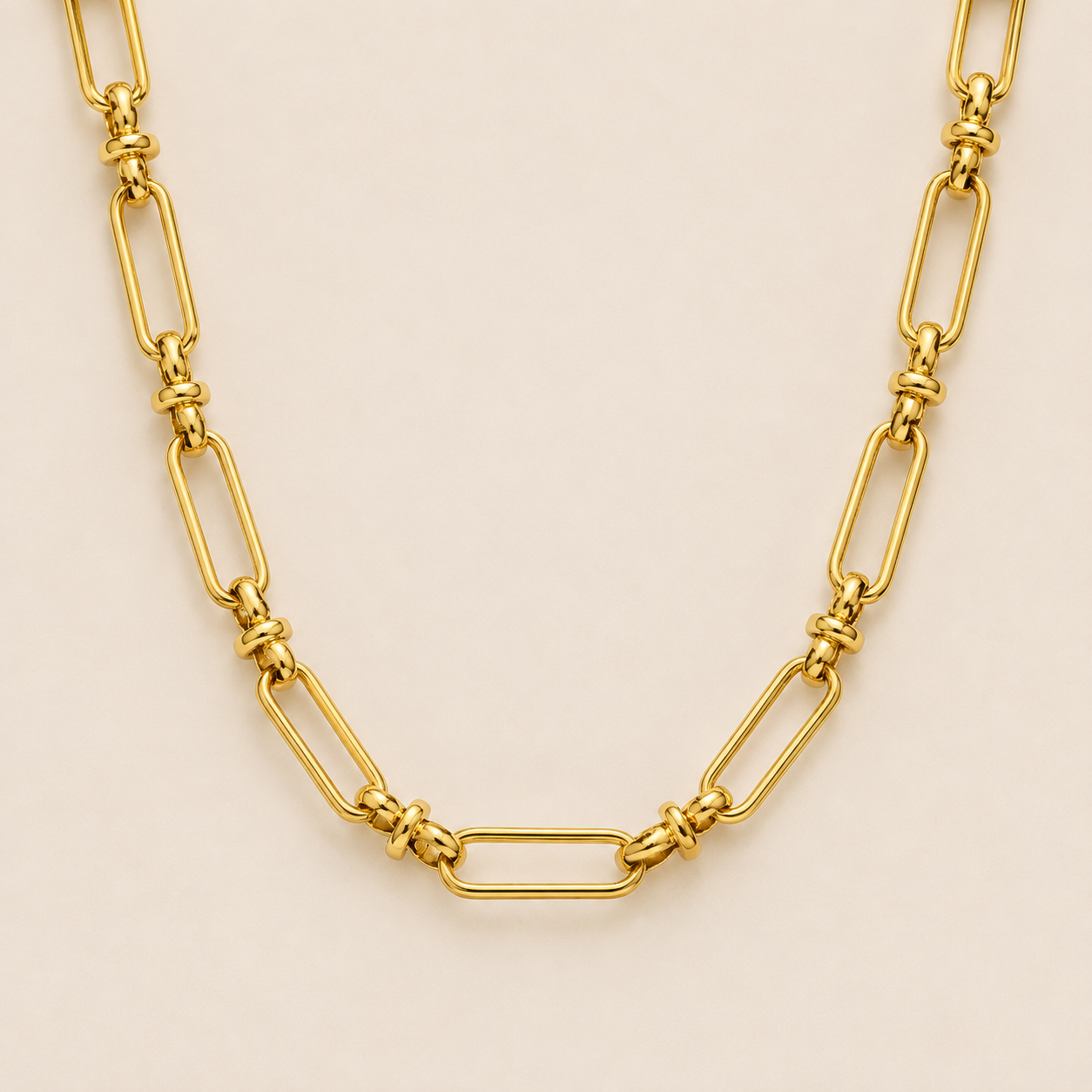 Gold paperclip-link chain necklace, the Iris NECKLACE, featuring elongated oval links joined by small round connectors, shown in close-up.